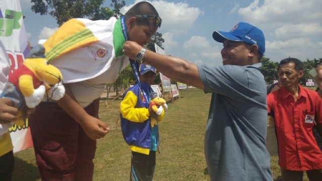 Pengurus Perpani M Ridwan mengalungkan medali perdana cabor panahan
